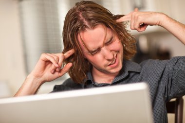 Young Man Getting Loopy While Using Laptop Computer clipart