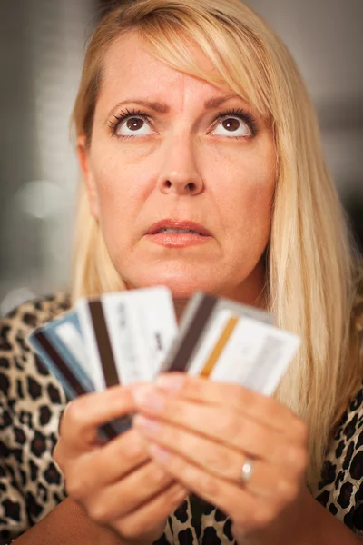 Расстроенная женщина, вопиющая на свои многочисленные кредитные карты — стоковое фото