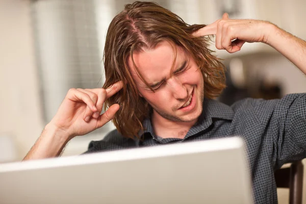 Mladý muž dostává loopy při práci s přenosným počítačem — Stock fotografie