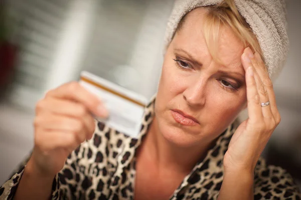 Mulher perturbada segurando seu cartão de crédito — Fotografia de Stock
