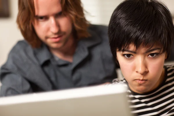 Hombre joven y mujer diligente usando el ordenador portátil juntos —  Fotos de Stock