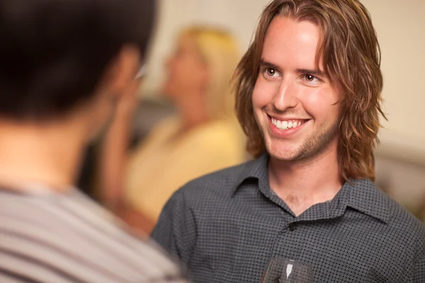 Jovem sorridente com copo de vinho socializando — Fotografia de Stock