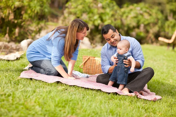 Счастливая смешанная расовая семья играет в парке — стоковое фото