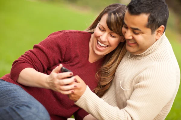 Atractiva pareja de raza mixta disfrutando de su teléfono con cámara —  Fotos de Stock