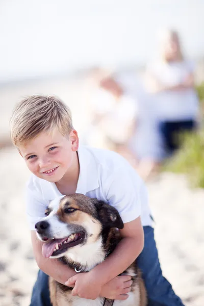 Przystojny młody chłopiec bawi się jego pies — Zdjęcie stockowe