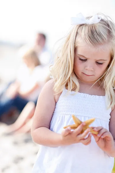 Adorable niña rubia con estrellas de mar —  Fotos de Stock