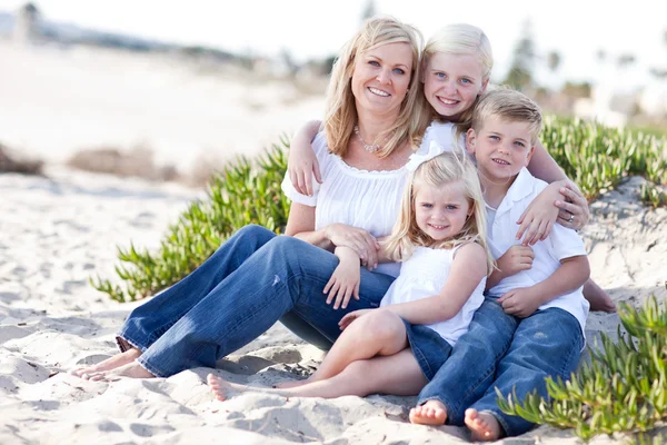 Atractiva mamá y sus lindos hijos en la playa — Foto de Stock