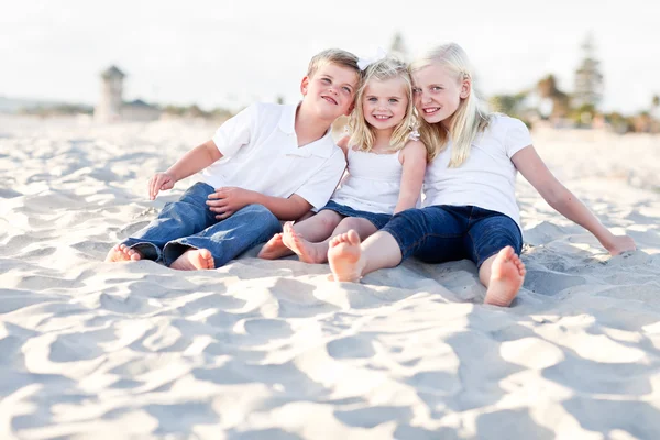 Schattig zussen en broer plezier op het strand — Stockfoto