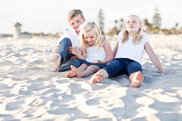 可爱的姐妹和兄弟在海滩很开心 — 图库照片