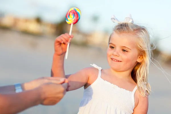 Schattig meisje plukken uit lollipop buiten — Stockfoto