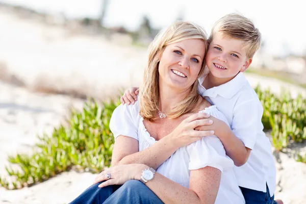 น่ารัก ลูกชาย กอด ของเขา แม่ ที่ the ชายหาด — ภาพถ่ายสต็อก