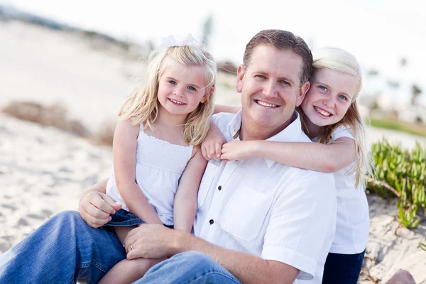 Schöner Vater und seine süßen Töchter am Strand — Stockfoto