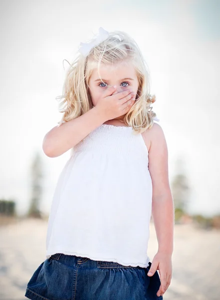 Schattig blauw eyed meisje die betrekking hebben op haar mond — Stockfoto