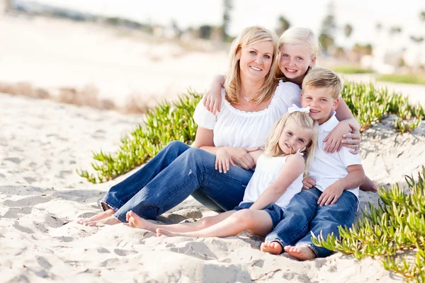 Привлекательная мама и ее милые дети на пляже — стоковое фото