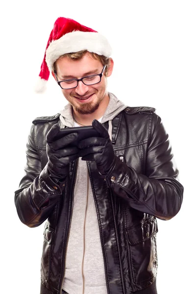 Junger Mann mit Weihnachtsmütze benutzt Handy — Stockfoto