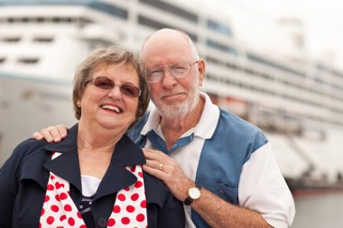 Senior Couple On Shore in Front of Cruise Ship While on Vacation. clipart