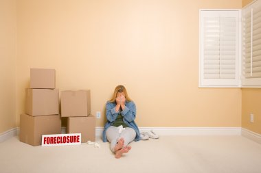 Upset Woman on Floor Next to Boxes and Foreclosure Sign clipart