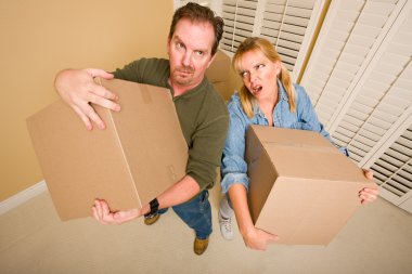 Exhausted Couple Holding Moving Boxes clipart
