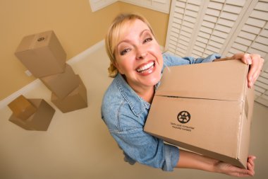 Excited Woman Holding Moving Boxes in Empty Room Taken with Extreme Wide Angle Lens. clipart