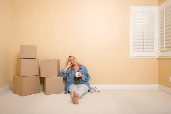 Happy Woman Relaxing Next to Boxes on Floor with Cup — Stock Photo, Image