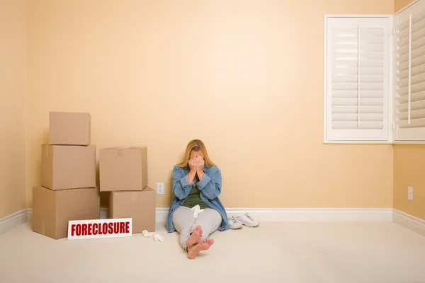 Mujer trastornada en el piso junto a cajas y carteles de ejecución hipotecaria — Foto de Stock
