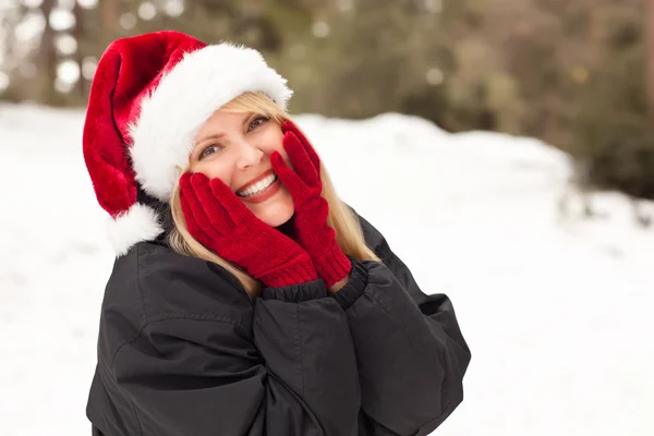 Karda eğleniyor çekici santa şapka giymiş sarışın kadın — Stok fotoğraf