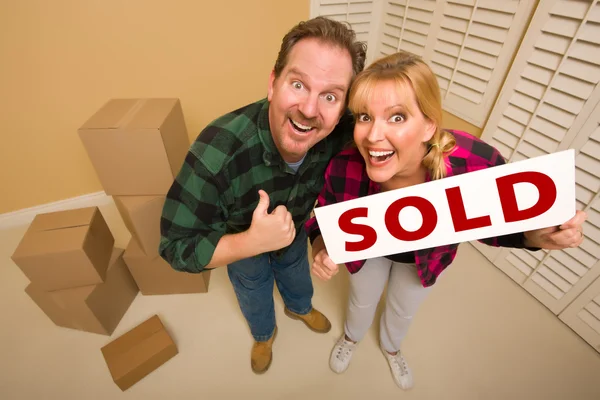 Goofy Couple Holding Sold Sign Surrounded by Boxes — Stockfoto