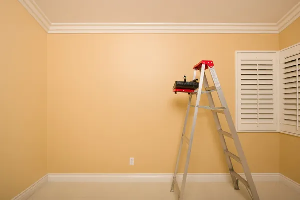 Habitación vacía con escalera, bandeja de pintura y rodillos — Foto de Stock