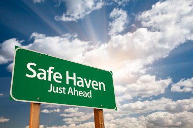 Safe Haven Green Road Sign with Dramatic Clouds, Sun Rays and Sky. clipart