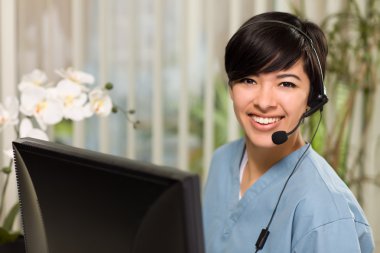 Attractive Multi-ethnic Young Woman Wearing Headset and Scrubs clipart