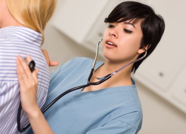 Attractive Mixed Race Young Female Doctor Using Stethoscope with clipart