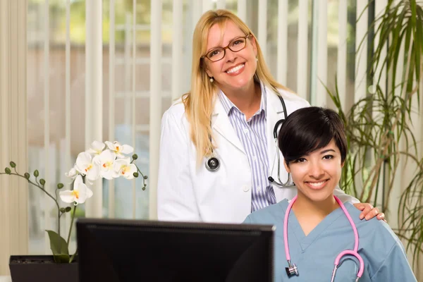 Lächelnde gemischte Rasse Ärztinnen oder Krankenschwestern im Büroalltag — Stockfoto