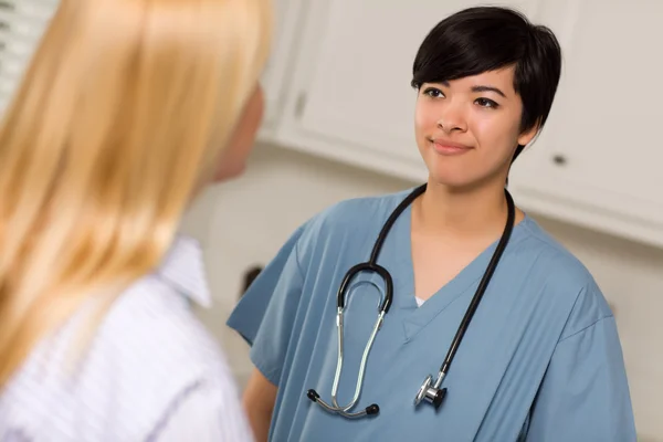 Çekici karışık ırk genç bir kadın doktor hasta ile konuşmak — Stok fotoğraf