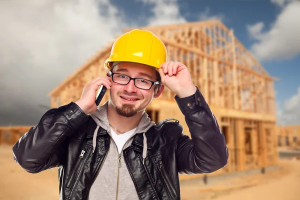 Trabajador joven de la construcción en el teléfono celular en frente de la casa —  Fotos de Stock