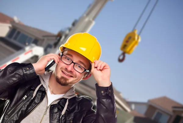 Genç inşaat işçisi vinç önünde cep telefonuyla — Stok fotoğraf