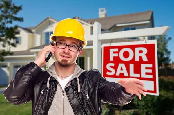Bauunternehmer mit Bollenhut vor Haus- und Immobilienschild — Stockfoto