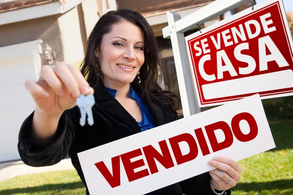 stock image Hispanic Woman Holding Vendido Sign in Front of Se Vende Casa Si
