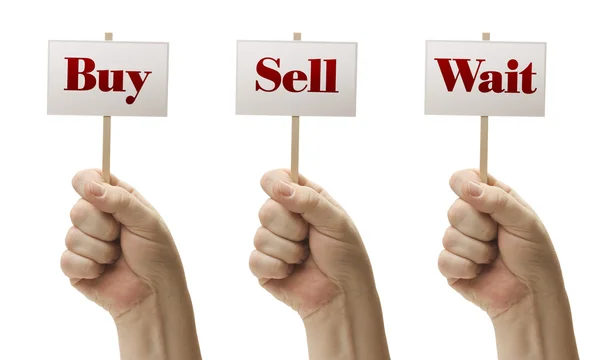 Три знака в кулаках, говорящие купить, продать и ждать — стоковое фото