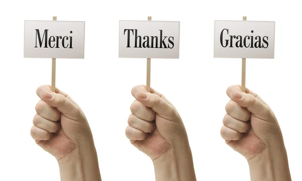 Drei Zeichen in den Fäusten, die merci, danke und gracias sagen — Stockfoto