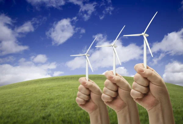 Мужские кулаки держат три ветряные турбины снаружи — стоковое фото