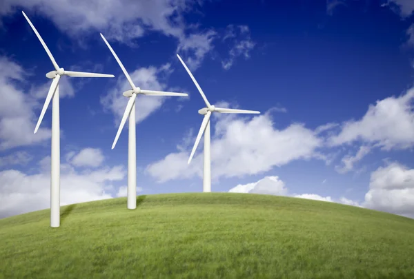 Tre vindkraftverk över gräsplan och blå himmel — Stockfoto