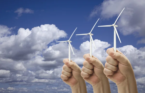 Мужские кулаки держат три ветряные турбины снаружи — стоковое фото