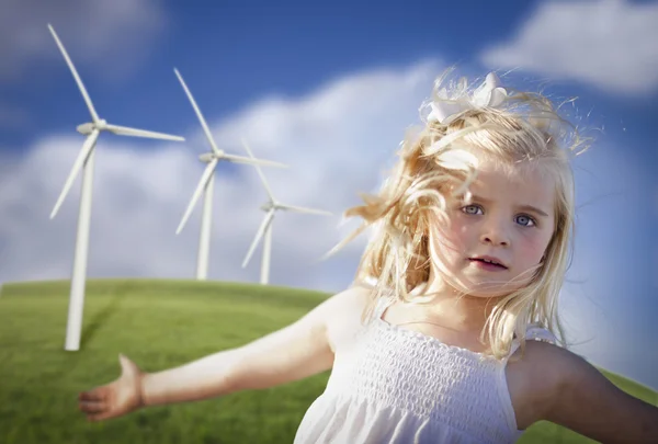Krásná mladá dívka hraje v oblasti větrné turbíny — Stock fotografie