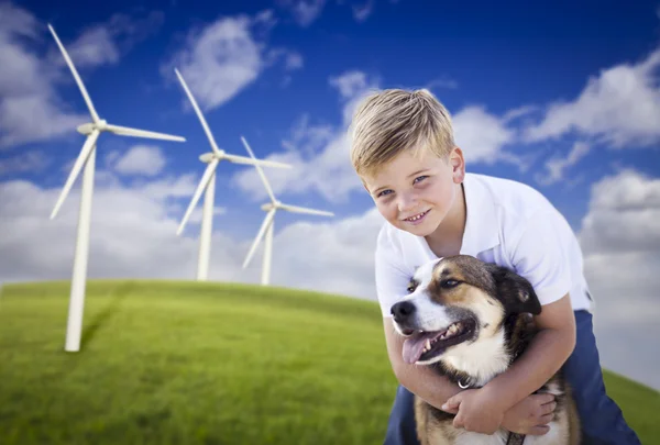 年轻的男孩和风力涡轮机字段中的狗 — 图库照片