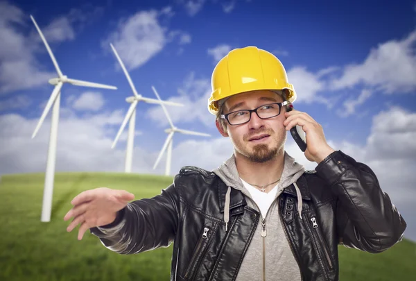 Hjälm bär ingenjör på telefon med turbiner bakom — Stockfoto