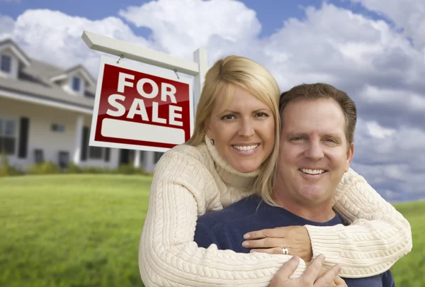 Couple heureux étreinte en face de l'immobilier signe et la maison — Photo