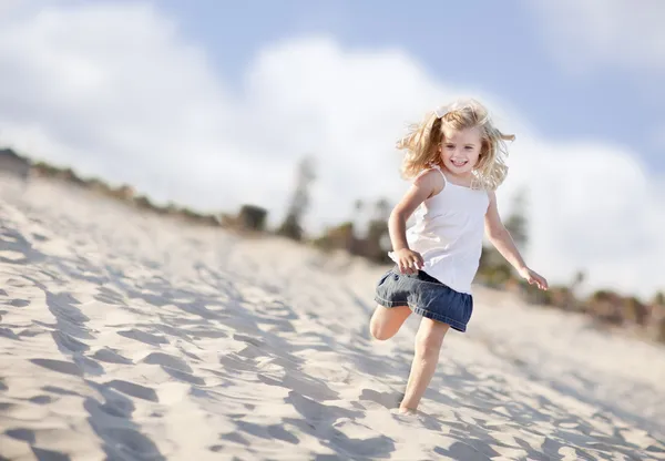 Счастливая маленькая девочка, развлекающаяся на пляже — стоковое фото