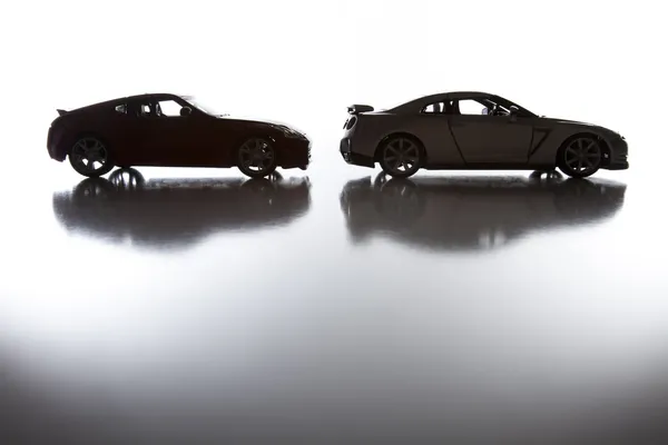 Silueta de coches deportivos en superficie reflectante —  Fotos de Stock