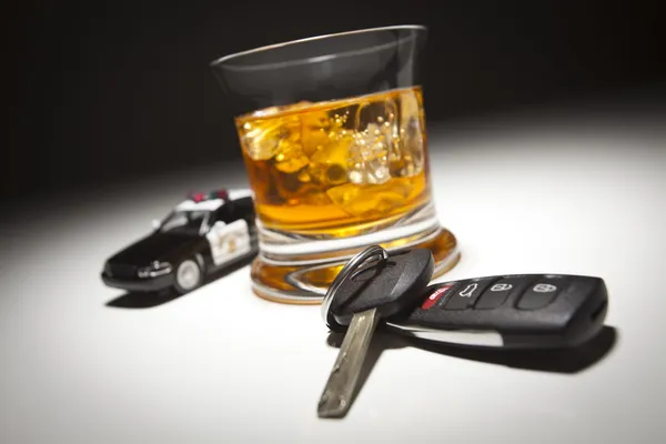 Streifenwagen der Autobahnpolizei neben alkoholischen Getränken und Schlüsseln — Stockfoto