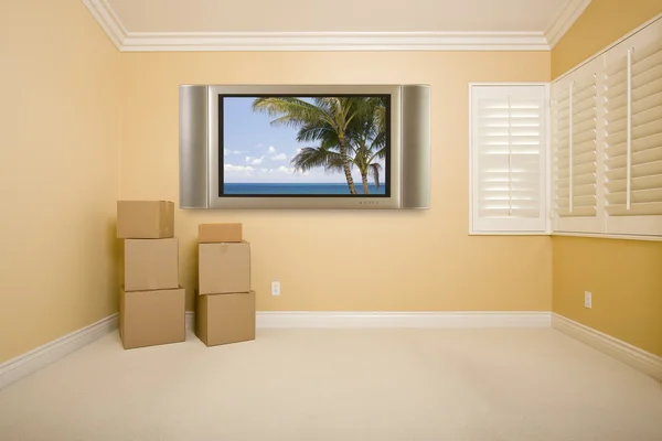 Τηλεόραση επίπεδης οθόνης στον τοίχο στο άδειο δωμάτιο με κουτιά — Φωτογραφία Αρχείου